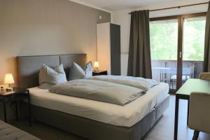 a bedroom with a large bed and a window at Pension Almhof Baumgarten in Bad Reichenhall