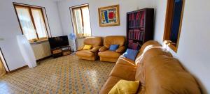 ein Wohnzimmer mit einem Sofa und 2 Stühlen in der Unterkunft Casa in montagna con giardino privato recintato in Andrate