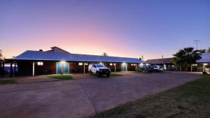 a building with a truck parked in a parking lot at The Major Mitchell Motel in Bourke