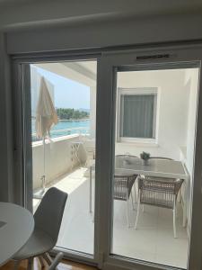 Habitación con balcón con mesa y sillas. en Apartman SeaSide, en Zadar