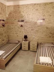 a bedroom with two beds and a brick wall at Spiros Apartments in Livadia