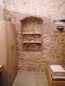 a bathroom with a stone wall with a sink at Spiros Apartments in Livadia