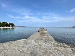 un muelle en el agua con gente en él en Apartman SeaSide, en Zadar