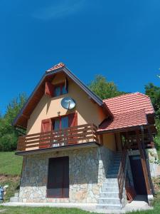 une maison avec un balcon et des escaliers. dans l'établissement Vila Mitrović, à Bajina Bašta