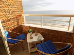 un balcón con 2 sillas, una mesa y el océano en Emilia's Cabin, en Guardamar del Segura