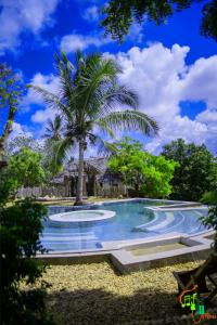 a swimming pool with a palm tree in the middle at AFLII Guest house in Mtwara