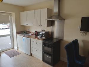 a kitchen with a stove and a microwave at Tara View Apartments in Garristown