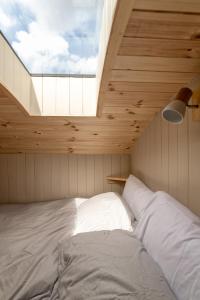 a bed in a room with a large window at Enchanting Tiny House with wood burner and hot tub in Cairngorms in Ballater