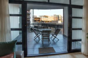 a patio with a table and chairs on a balcony at Stay at The Point - Exclusive Executives Escape in Durban