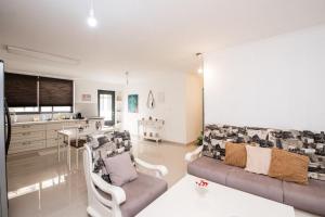 uma sala de estar com um sofá e uma cozinha em הבית בחורשה em Zihron Yaakov