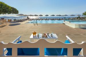a table with food on it next to a swimming pool at Elounda Ilion Hotel Bungalows in Elounda