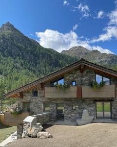 a log cabin with mountains in the background at LA RÊVERIE DE THUMEL - CHAMBRES in Rhêmes-Notre-Dame