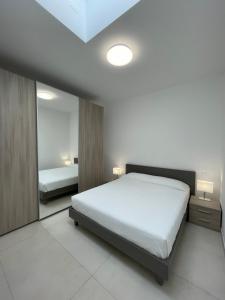 a bedroom with a white bed and a mirror at Carissimi 4 in Milan