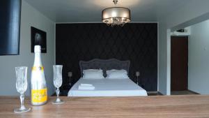 a bedroom with a bed and two wine glasses on a table at Luxury 1BR studio near Hanul Drumetului Bucharest in Bucharest
