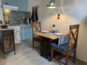 a kitchen with a wooden table with chairs and a counter at Pythagorion Harbour Studio in Pythagoreio