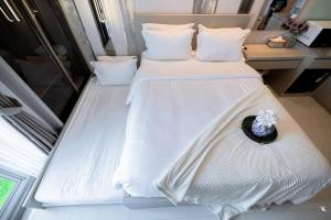 a bedroom with two beds with a hat on it at ermina at benson pakuwon mall in Surabaya
