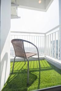 a chair sitting on a balcony with green grass at ermina at benson pakuwon mall in Surabaya