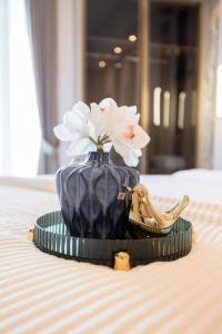 泗水的住宿－ermina at benson pakuwon mall，一张桌子上白色花的蓝色花瓶
