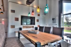 a dining room with a wooden table and chairs at Ferienhof Brandt in Hedwigenkoog