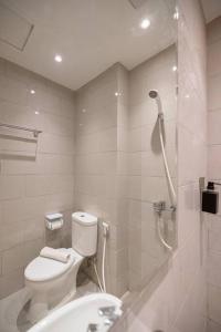 a bathroom with a shower and a toilet and a sink at ermina at benson pakuwon mall in Surabaya