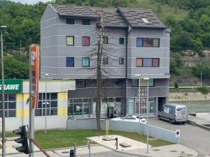 un edificio con una furgoneta estacionada frente a él en Apart & Hostel Konjic en Konjic