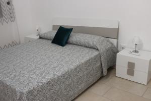 Un dormitorio con una cama con una almohada verde. en La Casetta di Nonna Angela, en Buseto Palizzolo