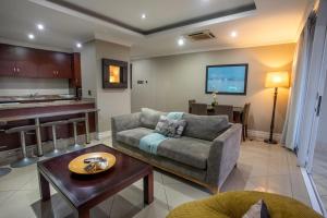 a living room with a couch and a table at Stay at The Point - Seaside Saunter in Durban
