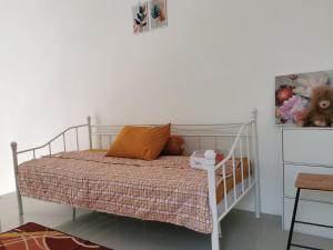 um quarto com uma cama branca e almofadas laranja em Ambarukmo Green Hill / MA 8 em Yogyakarta