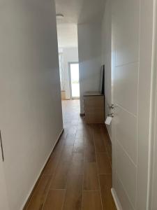pasillo vacío con puerta y suelo de baldosa en AMANTIUS APARTMENTS, en Borsh