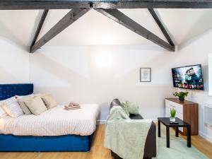 een woonkamer met een bed en een bank bij Spacious Studio with Parking - 10 Mins to Leeds Centre in Leeds
