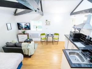 a kitchen and living room with a sink and a couch at Spacious Studio with Parking - 10 Mins to Leeds Centre in Leeds