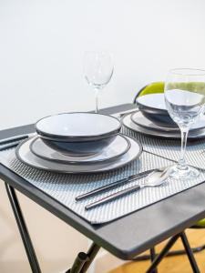 a black table with plates and wine glasses on it at Spacious Studio with Parking - 10 Mins to Leeds Centre in Leeds