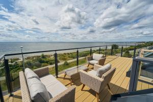 a balcony with chairs and a view of the ocean at Apartamenty Kuźnica "Morska 8" in Kuźnica