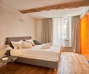 a bedroom with a large bed and a window at hideauts hotels Le Chevalier bleu in Monpazier