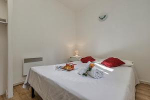 uma cama branca com almofadas vermelhas e uma bandeja de comida em Chamonix Sud - Triolet A206 - Happy Rentals em Chamonix-Mont-Blanc