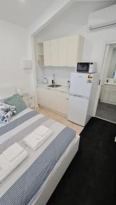 eine weiße Küche mit einem großen Bett in einem Zimmer in der Unterkunft Esplanade Gateway in Port Noarlunga South