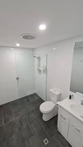 a bathroom with a toilet and a shower and a sink at Esplanade Gateway in Port Noarlunga South