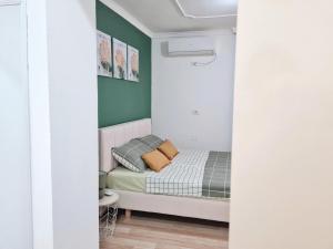 ein kleines Schlafzimmer mit einem Bett und grünen Wänden in der Unterkunft Casa 21 - the cutest in Tirana! in Tirana