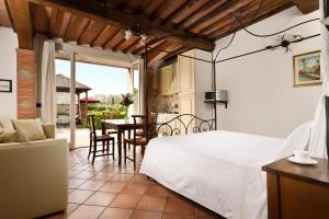 a bedroom with a bed and a table and chairs at San Francesco Country Resort in Vada +94 photos