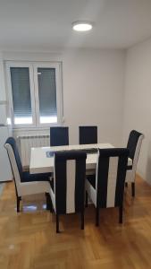 a dining room with a table and four chairs at Black and White in Pirot