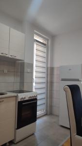 a small kitchen with a stove and a window at Black and White in Pirot