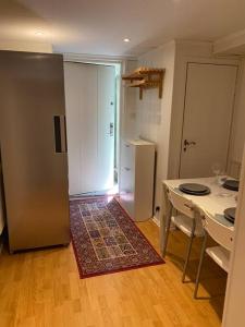 a small kitchen with a table and a refrigerator at Entire Basement Level in Eneby in Norrköping