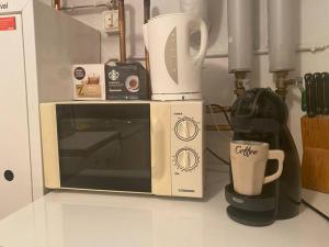 a microwave sitting on a counter next to a coffee maker at Entire Basement Level in Eneby in Norrköping