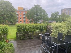 un patio con mesa y sillas en una terraza de madera en Entire Basement Level in Eneby, en Norrköping