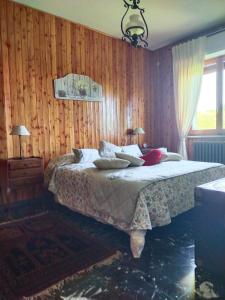 sypialnia z łóżkiem w drewnianej ścianie w obiekcie Orchidea w mieście Frabosa Soprana