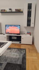 a living room with a flat screen tv on a wall at Black and White in Pirot +44 photos