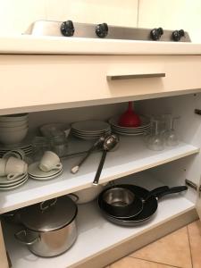 uma prateleira de cozinha cheia de pratos e utensílios em Residence il Tombolo em Principina a Mare