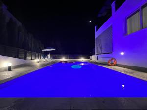 una gran piscina azul en un edificio por la noche en Villa Marina Sea-View Private Pool en Peyia