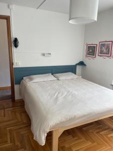 ガブイにあるAlbergo Molognaの青いヘッドボード付きのベッドルームの大型ベッド1台