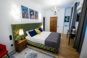 a bedroom with a bed with a green headboard at Metelitsa Hotel in Karagandy